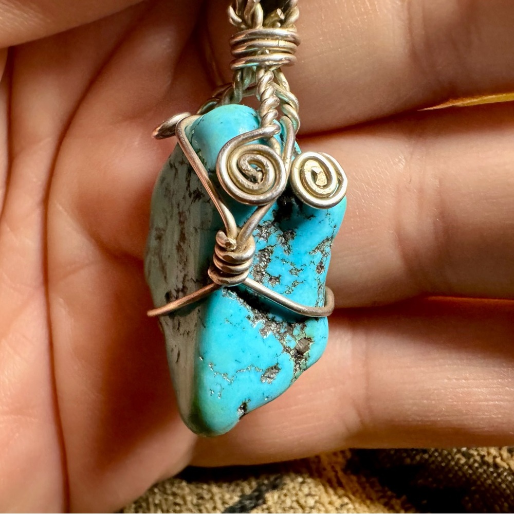 Wire wrapped turquoise pendant with black cord.
